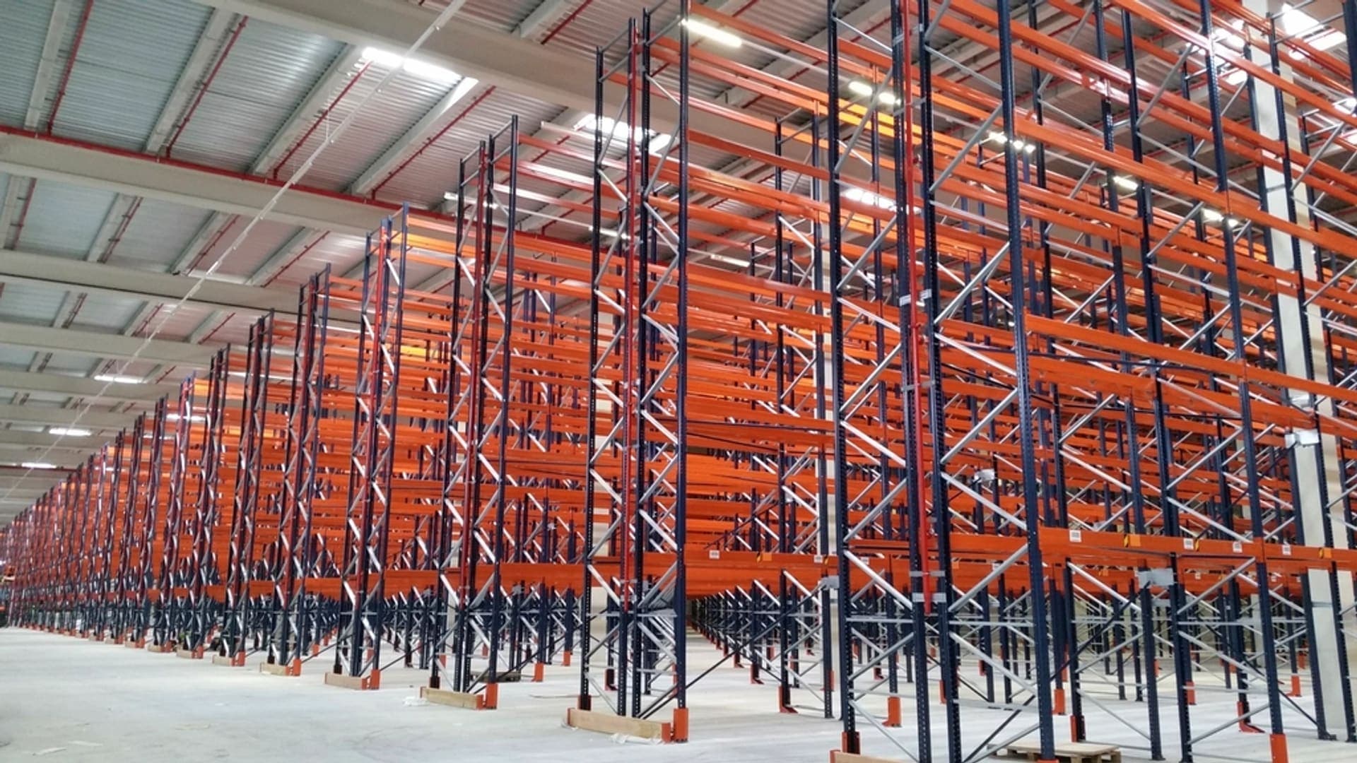 Wide-aisle pallet racking stacked with cased goods in a distribution warehouse